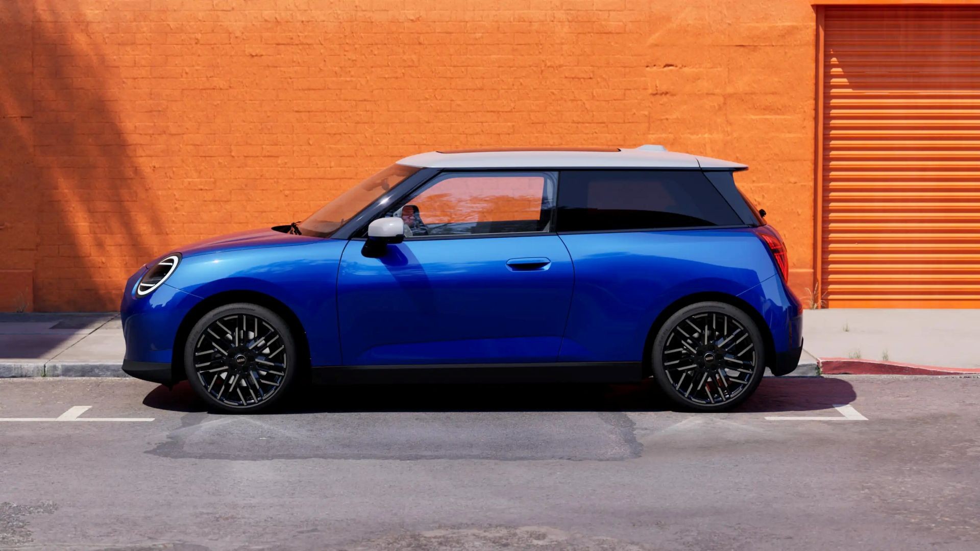 all-electric MINI Cooper side shot by orange wall